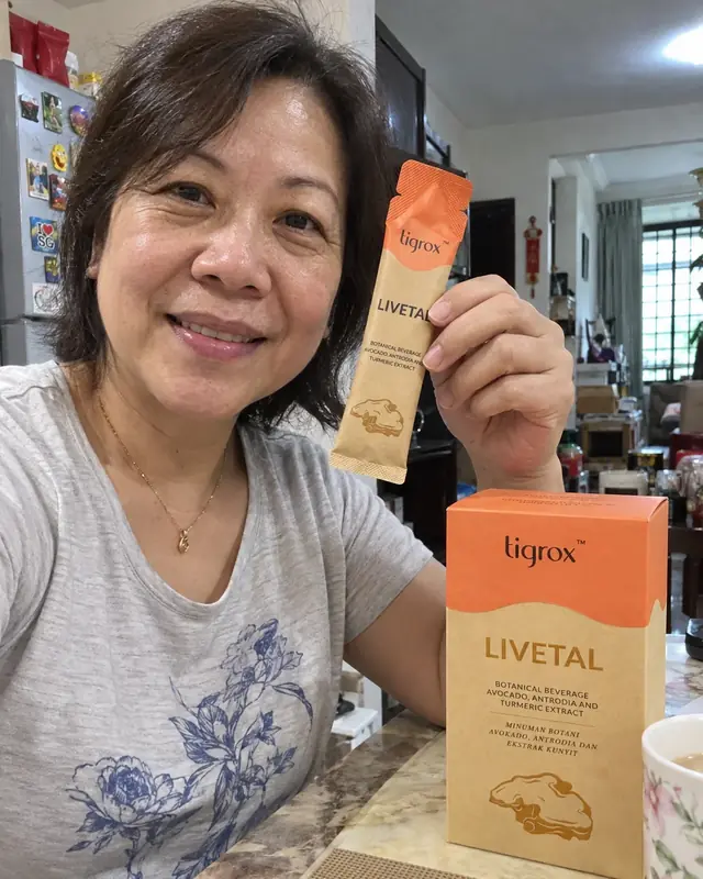 A woman holding a LIVETAL sachet with the box on the counter